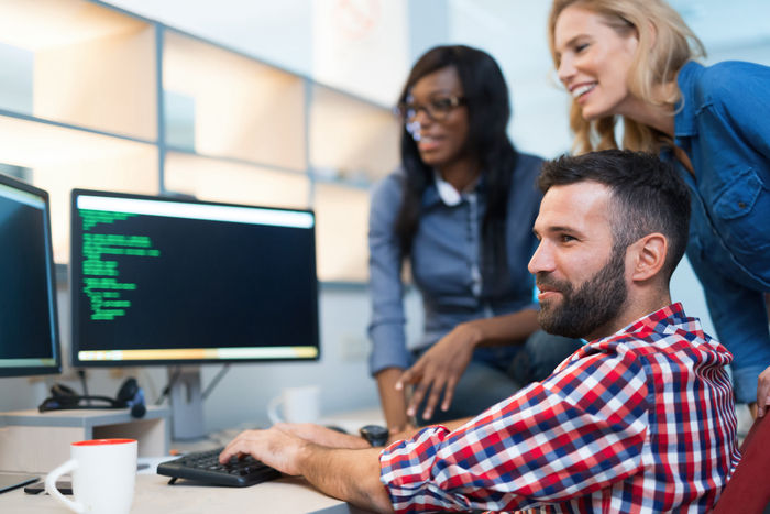Programmers cooperating at IT company developing apps